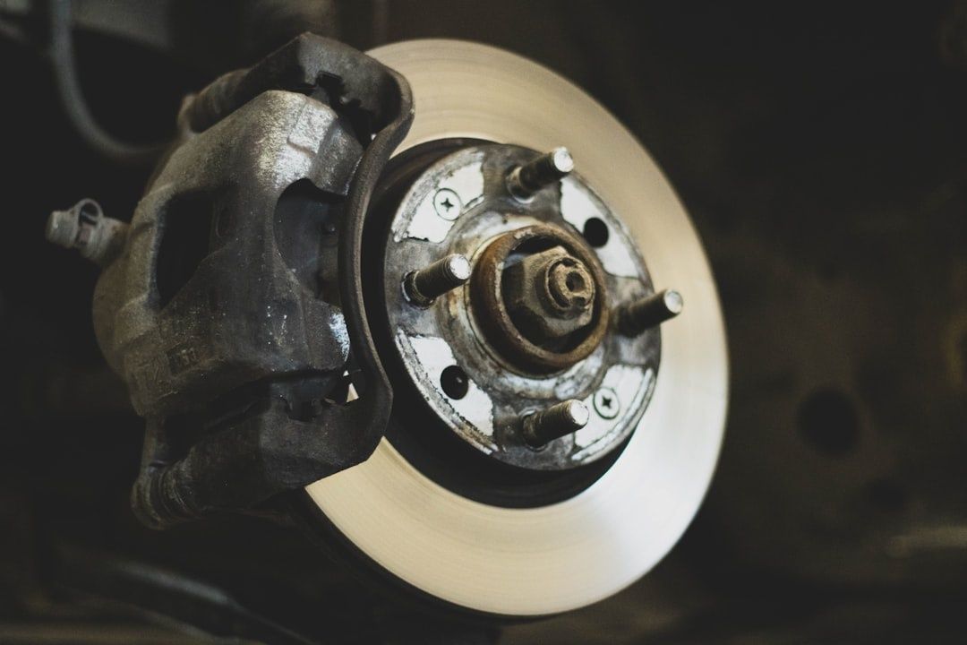 Close-up of a car brake caliper, rotor, and exposed wheel hub
